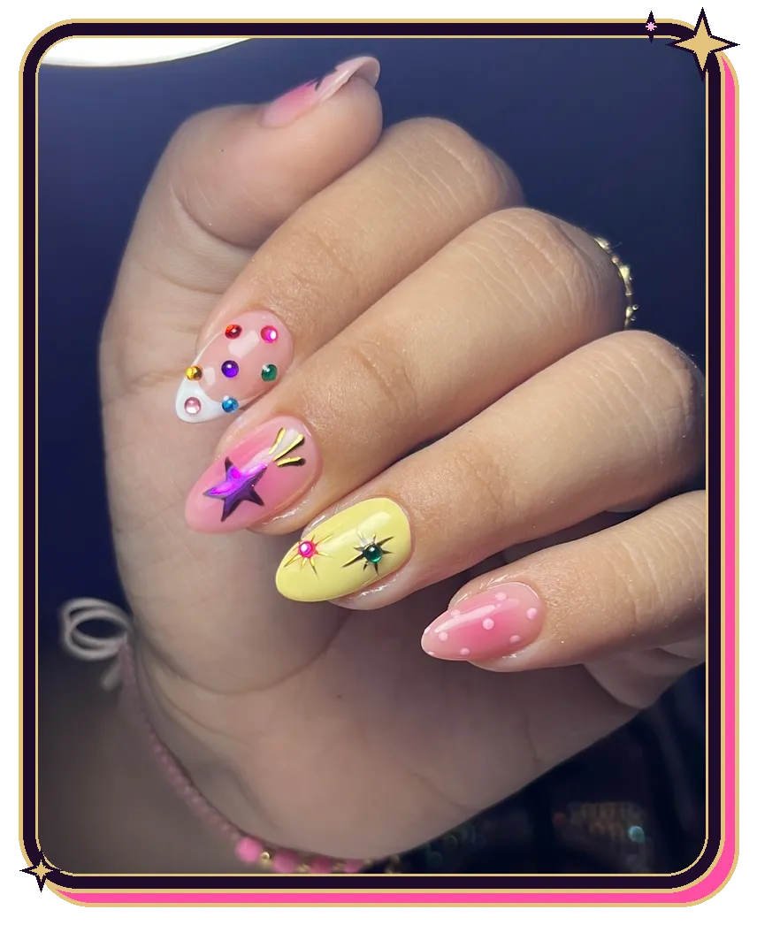 Uñas almendra con estrella morada, pedrería de colores y puntos rosados